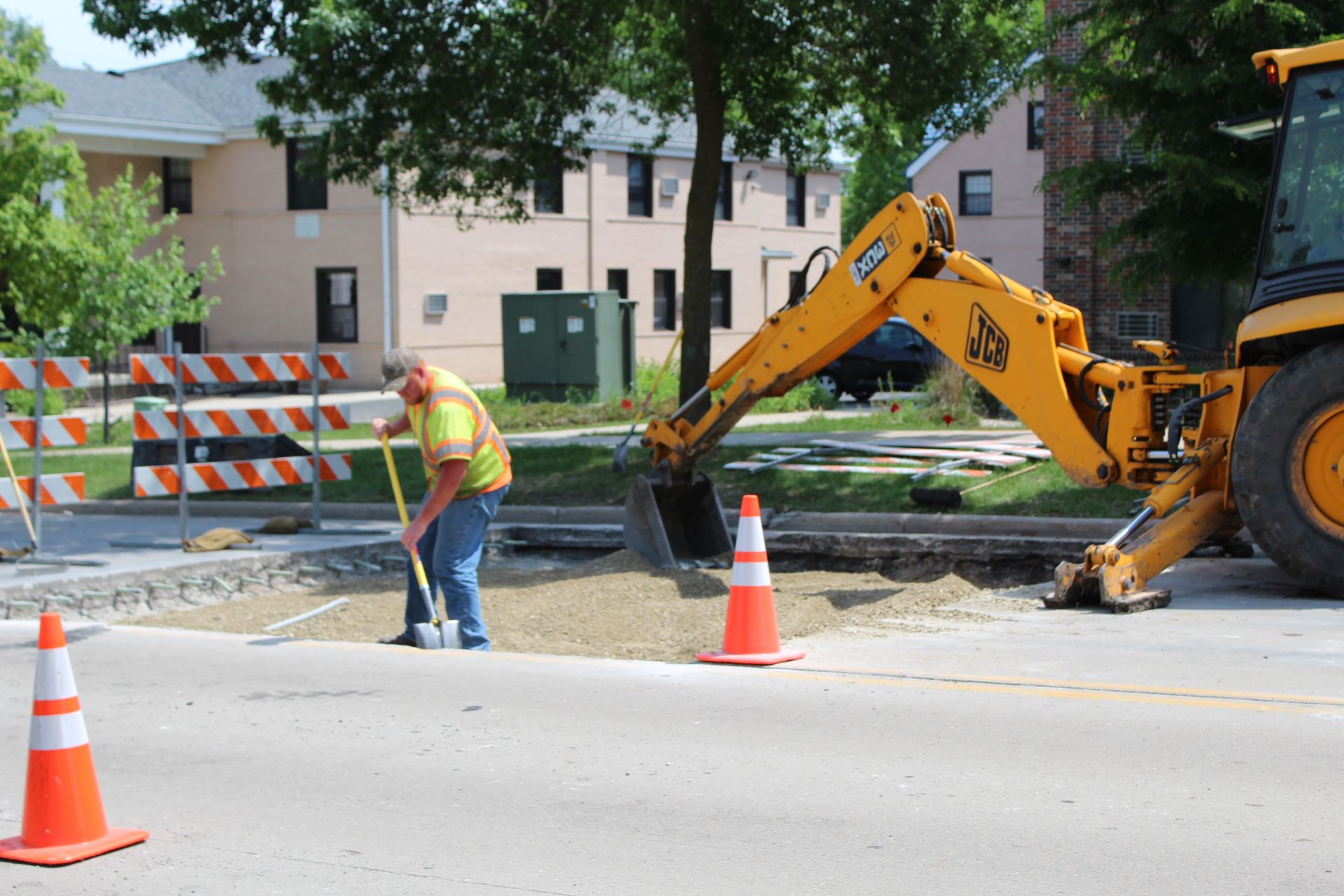 A man shoveling gravel in a road.